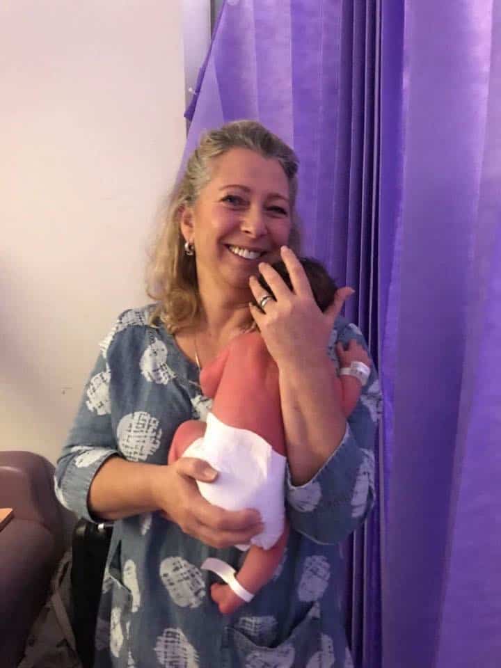Photo of Verina Henchy holding a doula clients baby