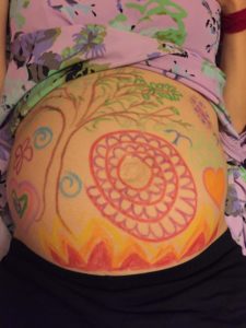 Photo of a hand decorated pregnant belly
