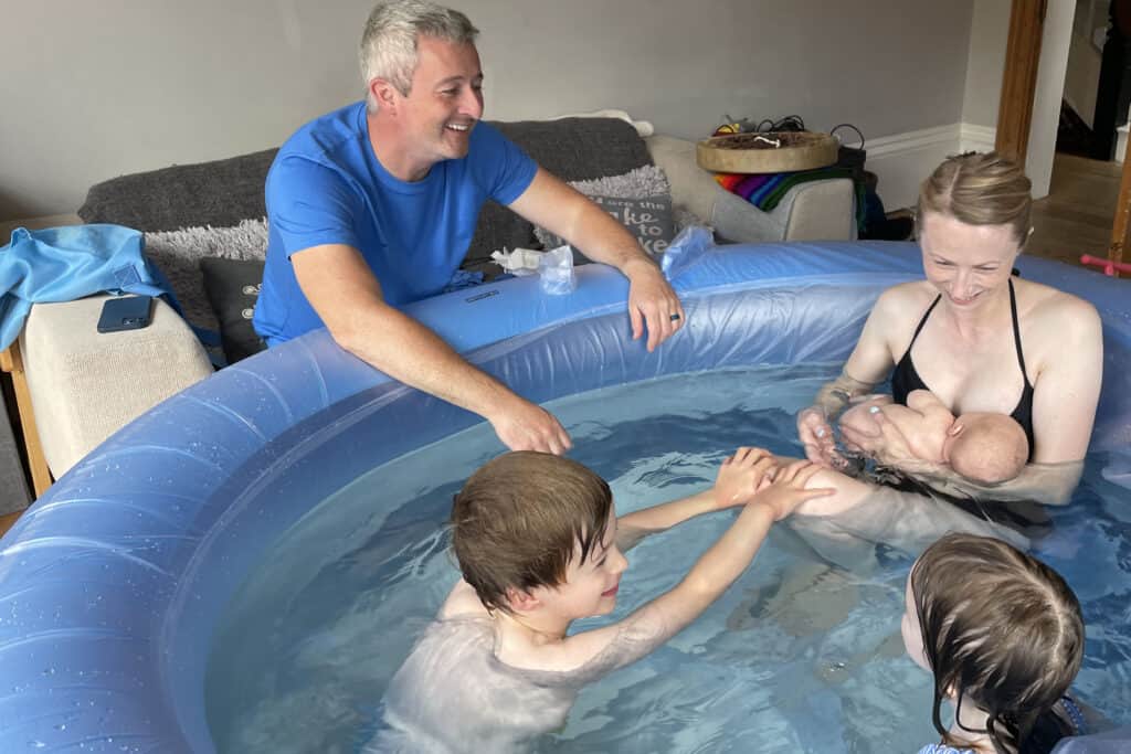 Photo of happy family with newborn baby in birthpool